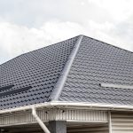 A corner close-up view of a green metal roof on a house