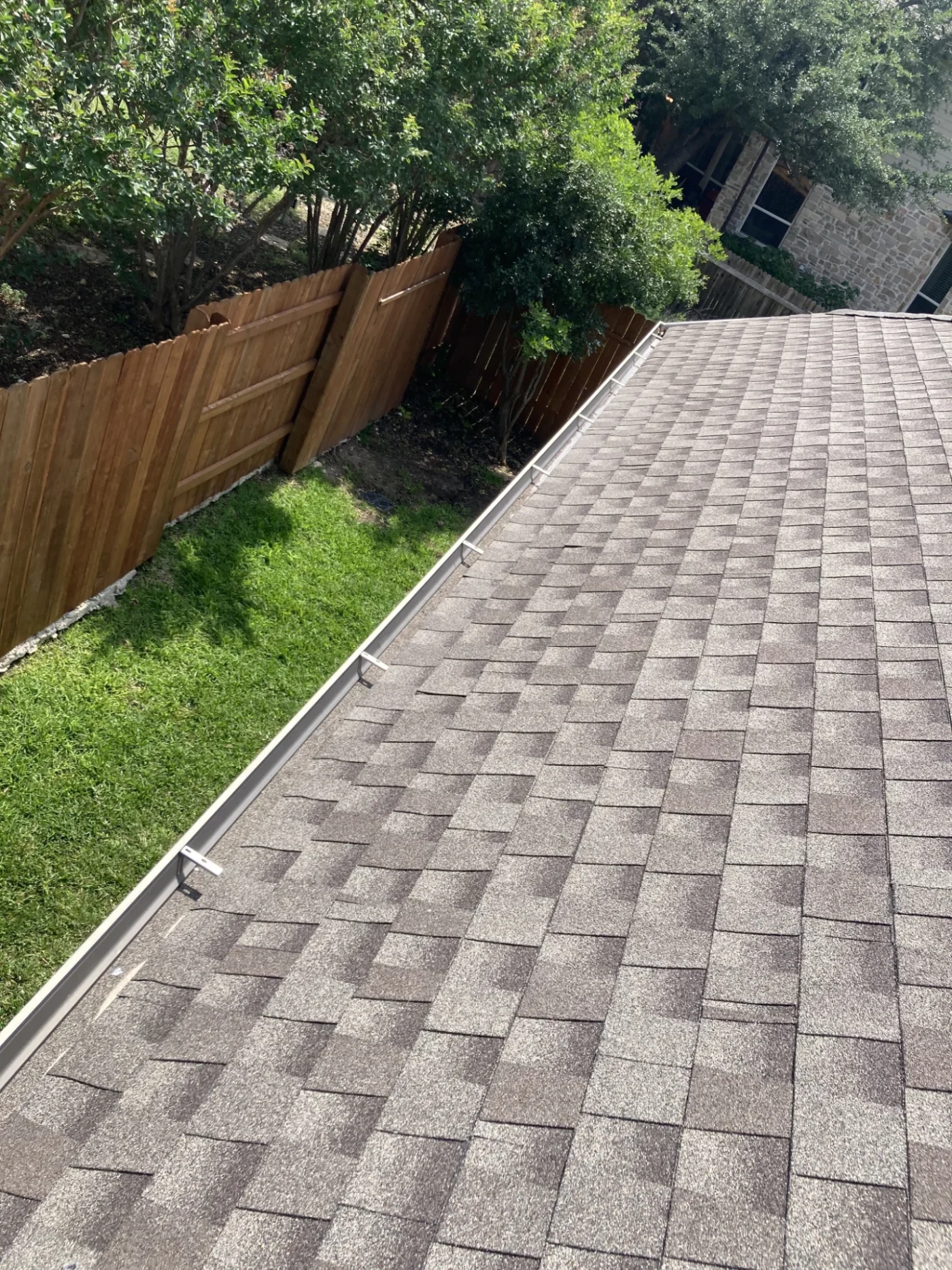 A close-up view of the edge of an asphalt shingle roof.