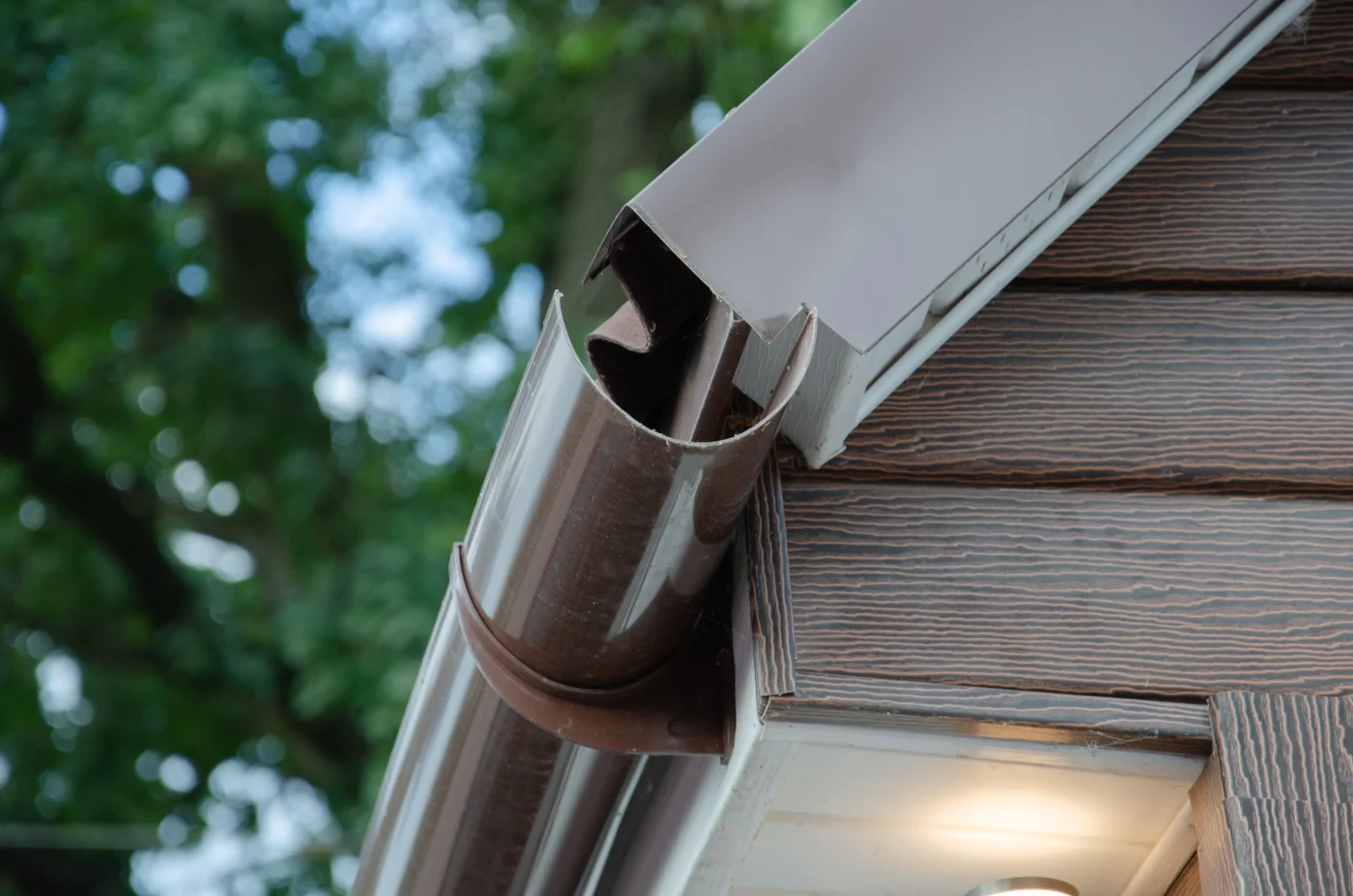 Reliable Exterior Services In Belterra, TX | Wolfpack Roofing An up-close view of the end of brown gutters on a house.